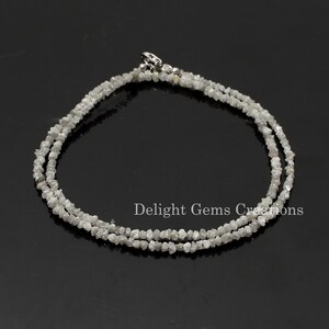 May include: A silver chain necklace made with rough, white diamonds. The necklace is double-stranded and has a silver clasp.
