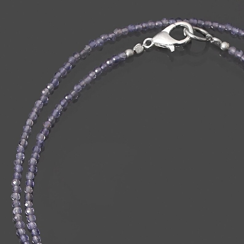 May include: A double strand necklace made of small, round, purple amethyst beads with a silver clasp.