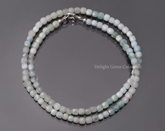 May include: A double-strand necklace made with light blue aquamarine beads. The beads are faceted and have a square shape. The necklace has a silver clasp.