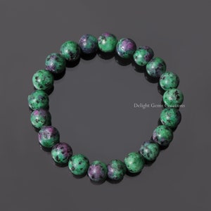 May include: A green and pink gemstone bracelet with round beads. The bracelet is made of natural stones and is a beautiful piece of jewelry.