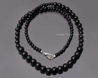 Puede incluir: Un collar de cuentas de ónix negro con un cierre de plata. El collar mide aproximadamente 45 cm de largo y presenta cuentas redondas.