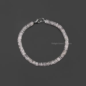 Peut inclure: Un bracelet délicat composé de perles de quartz facettées transparentes. Le bracelet est sécurisé par un fermoir argenté.