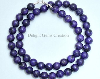 May include: A purple gemstone necklace with silver clasp. The necklace is made of round beads with a marbled pattern.