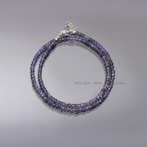Può includere: Una collana delicata realizzata con piccole pietre preziose blu scuro sfaccettate. La collana è realizzata con una chiusura in argento e misura circa 45 cm di lunghezza.