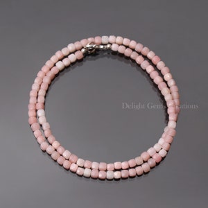 Puede incluir: Un delicado collar de ópalo rosa con cuentas de forma cuadrada. El collar está hecho de piedras preciosas naturales y tiene un cierre de plata.