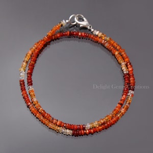 Puede incluir: Un delicado collar de doble cadena hecho con peque&ntilde;as cuentas de &oacute;palo de fuego facetadas, de color naranja, rojo y amarillo. El collar tiene un cierre de plata.