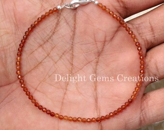 May include: A brown gemstone bracelet with a silver clasp. The bracelet is made of small, round beads and is approximately 7 inches in length.