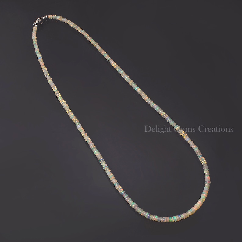 Puede incluir: Un collar delicado hecho de peque&ntilde;as cuentas de &oacute;palo iridiscente. El collar es de color plateado y tiene un cierre simple.