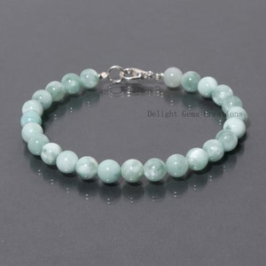 Könnte beinhalten: Ein grünes Jade-Armband mit einem silbernen Verschluss. Das Armband besteht aus runden Perlen und ist etwa 18 cm lang.