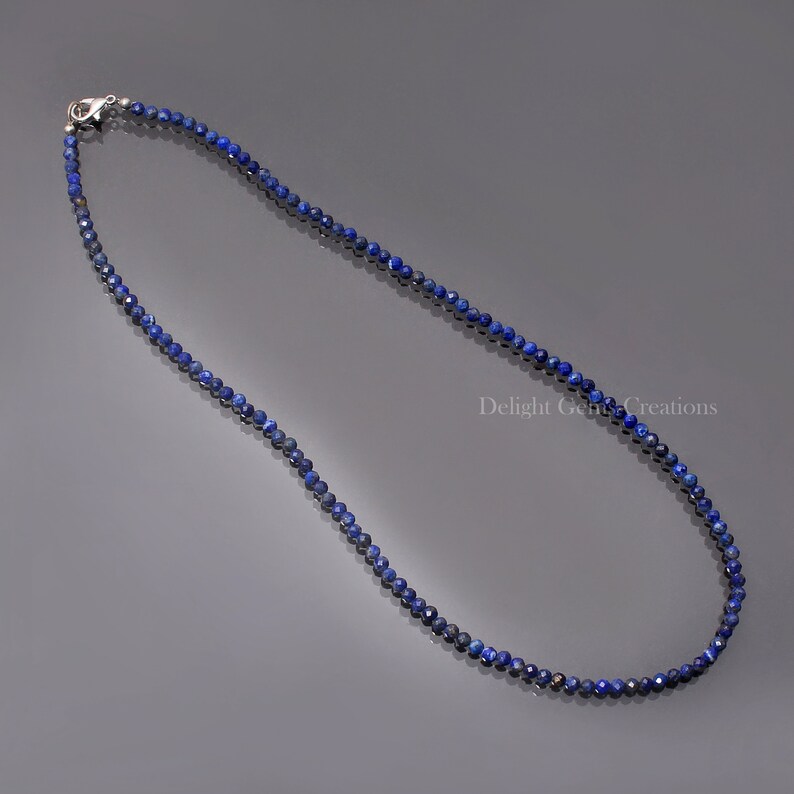 May include: A delicate necklace made of small, faceted lapis lazuli beads. The necklace is silver in colour and has a lobster clasp closure.