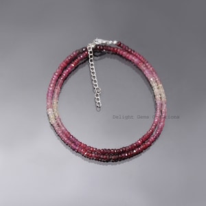 Könnte beinhalten: Eine zarte Halskette mit zwei Reihen aus kleinen, facettierten rosa und weißen Edelsteinen. Die Halskette hat einen silbernen Verschluss und ist etwa 40 cm lang.