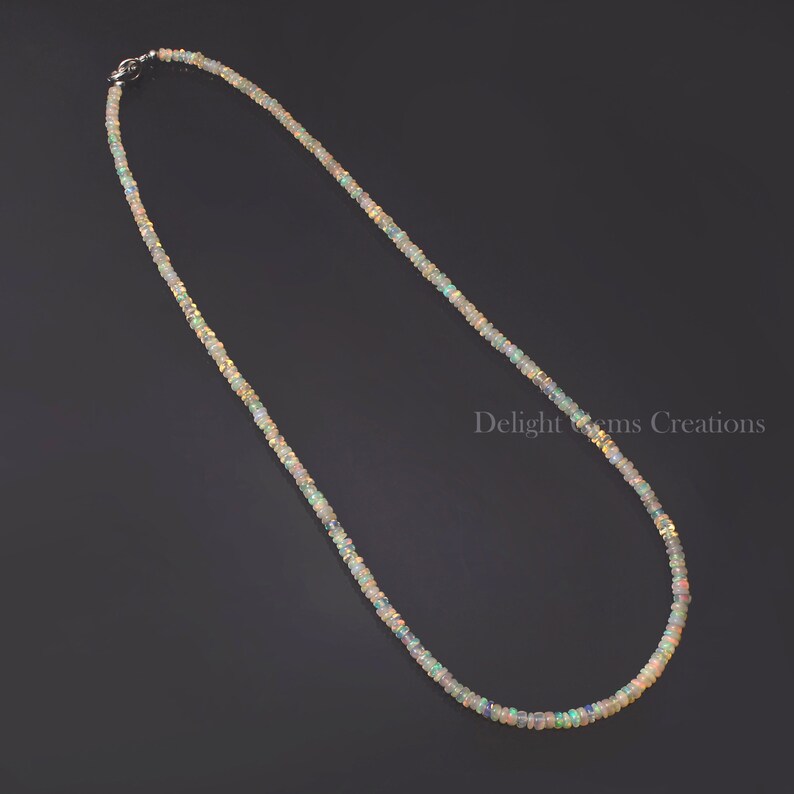 Puede incluir: Un collar delicado hecho de peque&ntilde;as cuentas de &oacute;palo iridiscente. El collar es de color plateado y tiene un cierre simple.