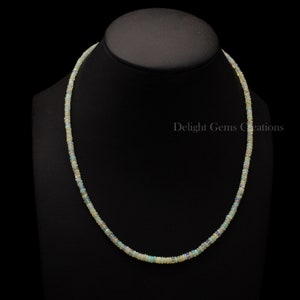 Puede incluir: Un collar delicado hecho de peque&ntilde;as cuentas de &oacute;palo blanco iridiscente. El collar mide aproximadamente 45 cm de largo y est&aacute; enhebrado en una cadena de plata.