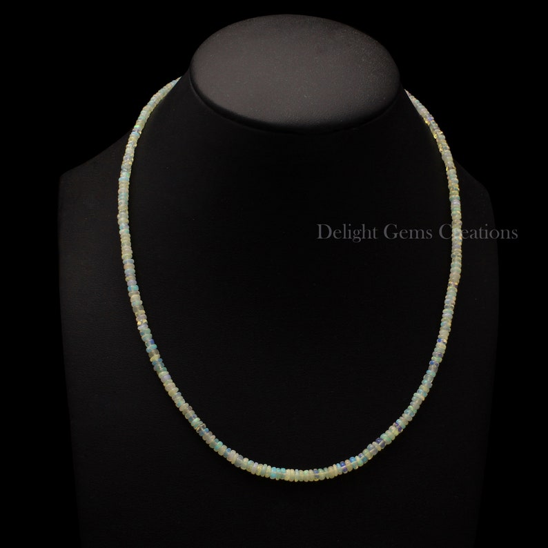 Puede incluir: Un collar delicado hecho de peque&ntilde;as cuentas de &oacute;palo blanco iridiscente. El collar mide aproximadamente 45 cm de largo y est&aacute; enhebrado en una cadena de plata.