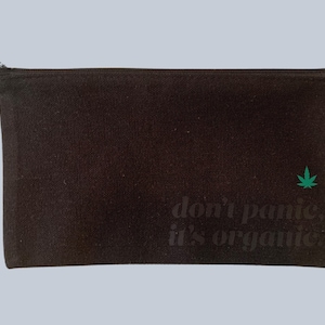 Könnte beinhalten: Schwarze Reißverschlusstasche mit einem grünen Cannabisblatt und dem Text "Keine Panik, es ist organisch".