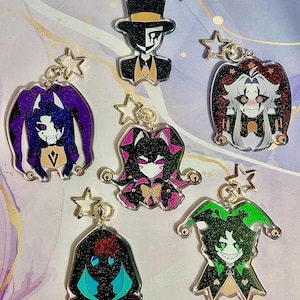 May include: Six acrylic keychains featuring stylised character illustrations with glitter finishes and star-shaped clasps. The designs include a top-hatted figure, a jester in purple, a jester in red and black, a pink-accented jester, a green jester, and a dark figure.