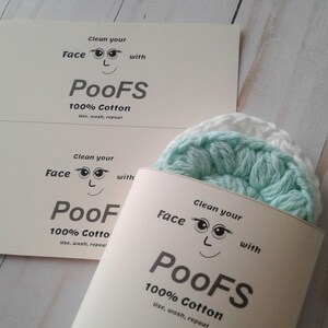 May include: A package of two light blue and white crocheted face cloths. The package is labeled "Clean your Face with PooFS 100% Cotton use, wash, repeat".