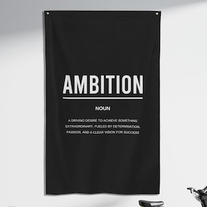Può includere: Un poster motivazionale in bianco e nero con la parola "AMBITION" in grassetto in lettere bianche. Il poster definisce l'ambizione come "un desiderio impetuoso di raggiungere qualcosa di straordinario, alimentato dalla determinazione, dalla passione e da una chiara visione del successo."