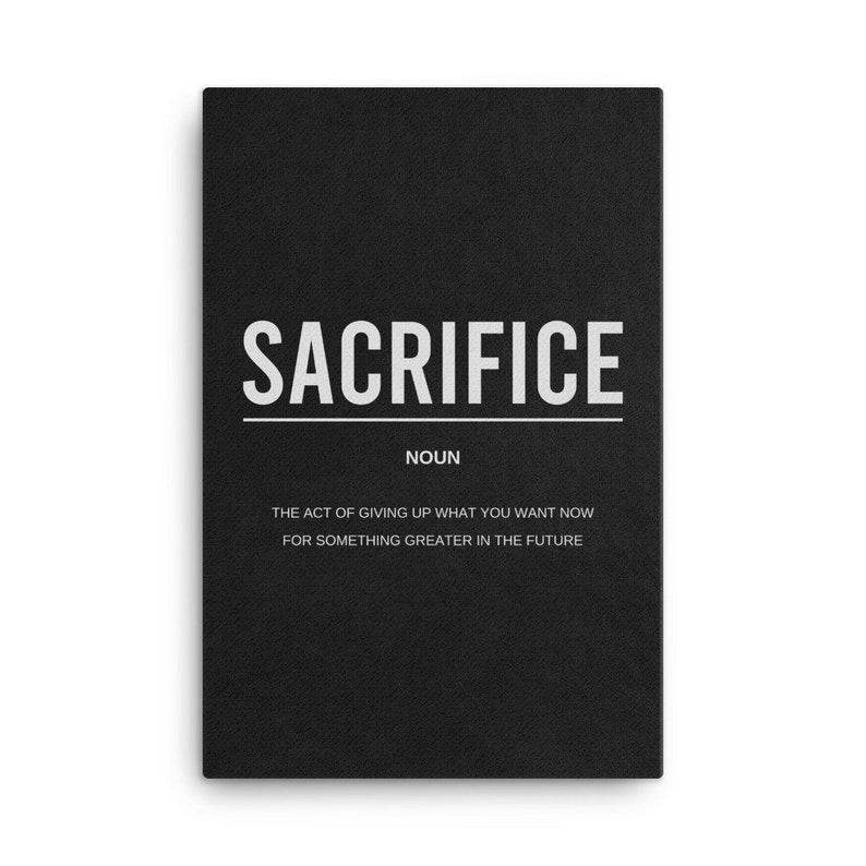 May include: Black and white typography print with the word "SACRIFICE" in bold, followed by the word "NOUN" and a definition: "The act of giving up what you want now for something greater in the future."