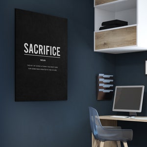 May include: A black and white motivational poster with the word "SACRIFICE" in large white letters. The definition of the word is written below in smaller white letters: "The act of giving up what you want now for something greater in the future."