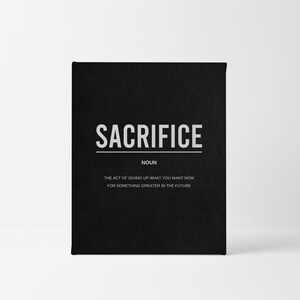 May include: A black card with the word "SACRIFICE" in white text. The card defines sacrifice as "the act of giving up what you want now for something greater in the future."