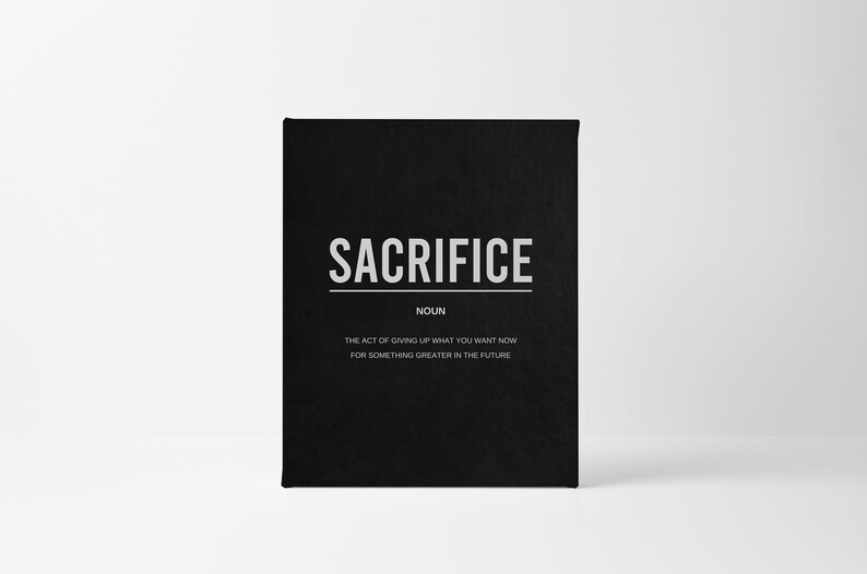 May include: A black card with the word "SACRIFICE" in white text. The card defines sacrifice as "the act of giving up what you want now for something greater in the future."