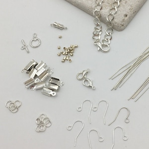 May include: Assortment of silver jewellery making supplies including jump rings, earring hooks, clasps, chain, head pins, and crimp beads.