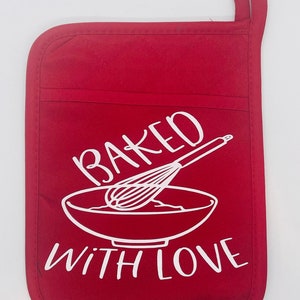 May include: A red pot holder featuring a white graphic of a whisk and bowl, with the words "BAKED WITH LOVE". It has a hanging loop and the text "Design #3" at the bottom.