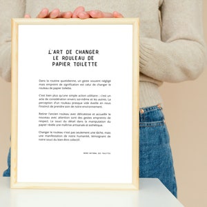 May include: A framed print with a white background and black text in French. The text reads "L'art de changer le rouleau de papier toilette." The text discusses the simple act of changing a toilet paper roll and how it is more than just a chore. It is a sign of respect for oneself and others, as well as a way to show care for the environment.