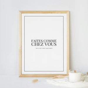 May include: A framed print with the text "Faites comme chez vous - Mais pas trop longtemps." in black lettering on a white background. The frame is made of light wood.