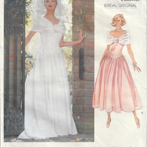 May include: A Vogue Patterns sewing pattern envelope for a bridal dress, number 2425. The cover features a photograph of a white gown with a matching shawl and a detailed illustration of a pink version of the same dress design with a floral accent.
