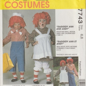 Pode incluir: Padrão de fantasias McCall's para Raggedy Ann e Andy. O padrão inclui tamanhos para adultos e crianças. A imagem mostra duas crianças usando as fantasias, completas com perucas de fio vermelho e rostos pintados.