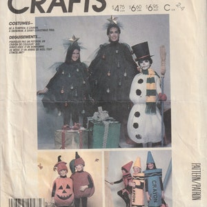 Puede incluir: Patrón de costura vintage de McCall's Crafts con ideas de disfraces. Los disfraces incluyen una calabaza, un crayón, un muñeco de nieve y un brillante árbol de Navidad. La imagen muestra modelos con los disfraces, con texto en inglés y francés.