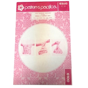 May include: A pink and white sewing pattern package from "patterns pacifica" with the number 6100. The package contains instructions for making a small or large bag. The package has a floral design.