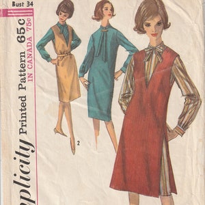 May include: Vintage Simplicity sewing pattern showing three dress designs. The pattern includes a dress with a V-neckline and a sleeveless dress. The pattern is marked "Miss Size 14 Bust 34". The price is 65c in the US and 75c in Canada.