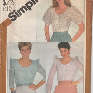 May include: Vintage Simplicity sewing pattern featuring three blouse designs. The pattern includes a size 12 Misses size. The image shows the blouse designs with details like puffed sleeves and ruffled accents. The pattern is labeled "Overnight Success".