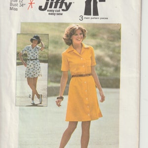 May include: Simplicity sewing pattern 6962, showing a woman in a yellow button-down dress with a brown belt. The pattern includes a smaller image of a similar dress. The text reads "Jiffy easy cut easy sew". Size 12, bust 86 cm.