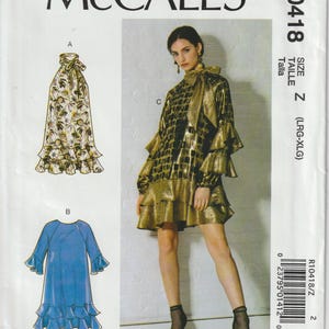 May include: McCall's sewing pattern R10418 featuring three dress designs. The pattern includes a long dress with a floral print, a blue dress with ruffled sleeves and hem, and a gold and black dress with ruffled sleeves and hem. Size Z (LRG-XLG).