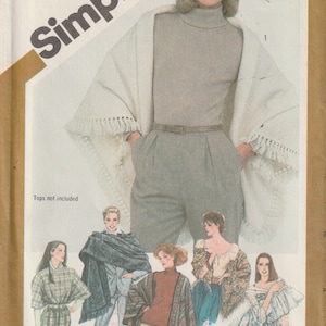 May include: Vintage Simplicity sewing pattern envelope featuring a woman wearing a white fringed shawl and gray pants. The envelope includes illustrations of various outfit styles, including shawls and tops. The text "Simplicity" is prominently displayed.