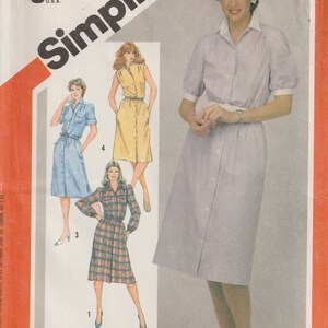 May include: Vintage Simplicity sewing pattern 5894 featuring shirt dresses. The cover shows illustrations of the dresses in blue, yellow, and plaid fabrics. The main image shows a woman wearing a striped dress. The pattern is for sizes 20, 22, and 24.