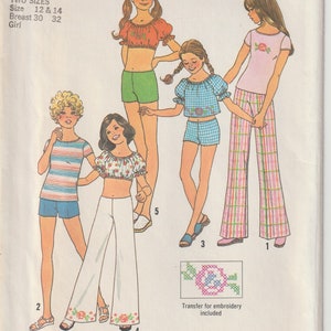 Puede incluir: Patrón de costura Simplicity 7511 vintage con ilustraciones de niñas con diferentes conjuntos, incluyendo shorts, pantalones y tops. El patrón incluye dos tallas y una transferencia para bordado. El texto "SIMPLE-TO-SEW" se muestra en la parte inferior.
