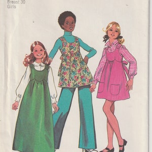 May include: Vintage Simplicity sewing pattern for girls' dresses and trousers. The pattern cover shows illustrations of three girls wearing the garments. The cover text reads "5762 Simplicity" and includes size and price information.
