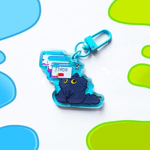 May include: A blue acrylic keychain featuring a cartoon cat with yellow eyes and a computer error message. The keychain has a blue clasp and a design of computer windows with the word "ERROR". The cat is dark blue.