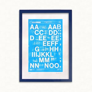May include: A blue and white alphabet chart with the letters A through N printed in a bold, sans-serif font. The letters are arranged in rows, with each letter repeated multiple times. The chart is framed in a dark blue frame.