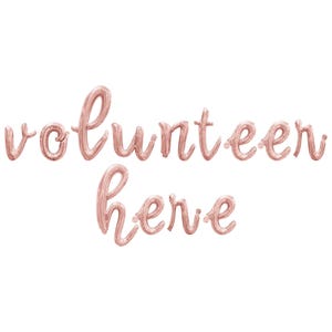 May include: Rose gold foil balloons spelling out "volunteer here" in a cursive font.