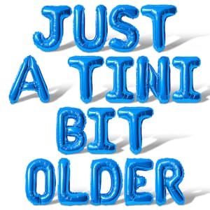 May include: Blue foil balloons spelling out "JUST A TINY BIT OLDER" against a white background. The balloons are inflated and cast shadows, creating a festive and celebratory atmosphere. Ideal for a birthday.