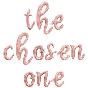 May include: Rose gold foil balloons spelling out "the chosen one".