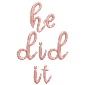 May include: Rose gold foil balloons spelling out "he did it" in a cursive font.