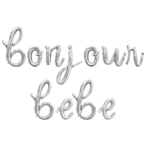 May include: Silver foil balloons spelling out "Bonjour Bebe" in elegant cursive script. The balloons are inflated and arranged against a white background, perfect for a baby shower or nursery decor.