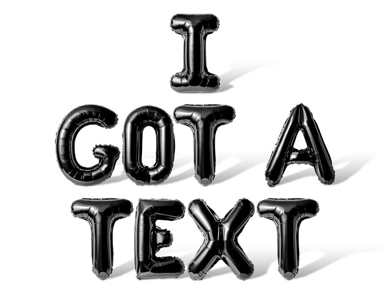 May include: Black balloon letters spelling out "I GOT A TEXT" on a white background.